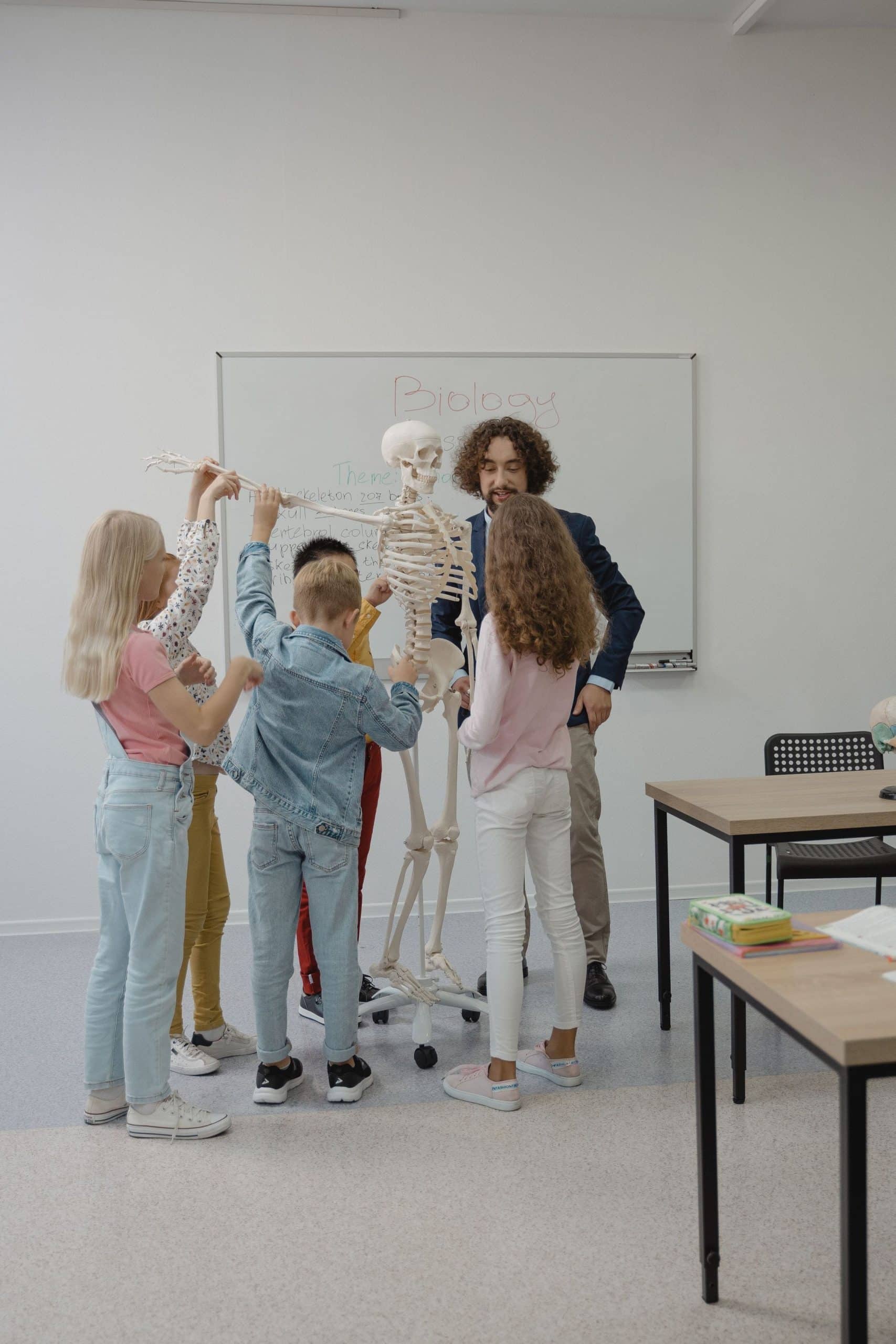 Docente enseñando anatomía a un grupo de niños en una sala de clases